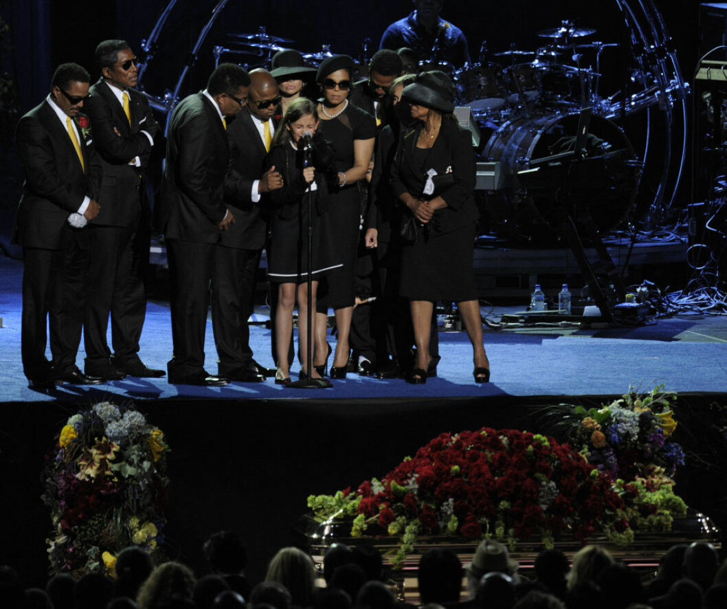 Paris Jackson under Michael Jacksons begravning 2009, omringad av familjen. Fans gathered to attend the public memorial service for legendary pop star Michael Jackson. Held at the Staples Center, the memorial service featured eulogies and notes of condolence by Queen Latifah, Smokey Robinson and tribute performances by Mariah Carey, Stevie Wonder as well as others. Celebrities and members of Jackson's family were in attendance. The performer passed away at age 50 on June 25, 2009 from a cardiac arrest. /// Paris Jackson (C) is supported by family members after speaking during the memorial service