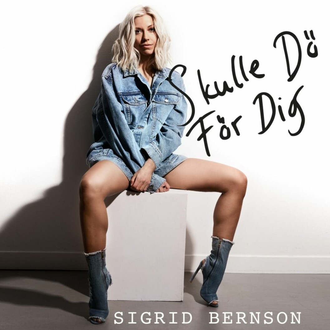 Omslaget för Sigrid Bernsons nya singel Skulle dö för dig. Sigrid Bernson sitter på en vit kloss i jeansskjorta och jeansskor