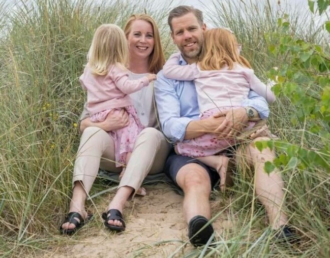 Annie Lööf tillsammans med maken Carl-Johan Lööf och barnen Ester och Saga. Annie Lööf sitter på stranden tillsammans med maken Carl-Johan Lööf med barnen Ester och Saga i varsin famn