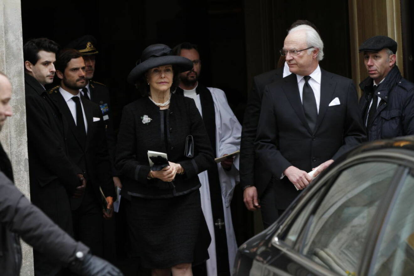Kung Carl Gustaf, drottning Silvia och prins Carl Philip lämnar kyrkan efter begravningsceremonin. 