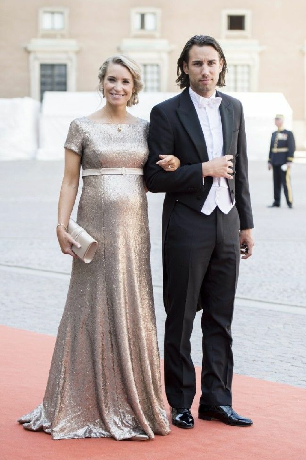 Prinsessan Sofias kompis Olivia Rehn bar den guldfärgade dräkten rean under prinsbröllopet i somras.