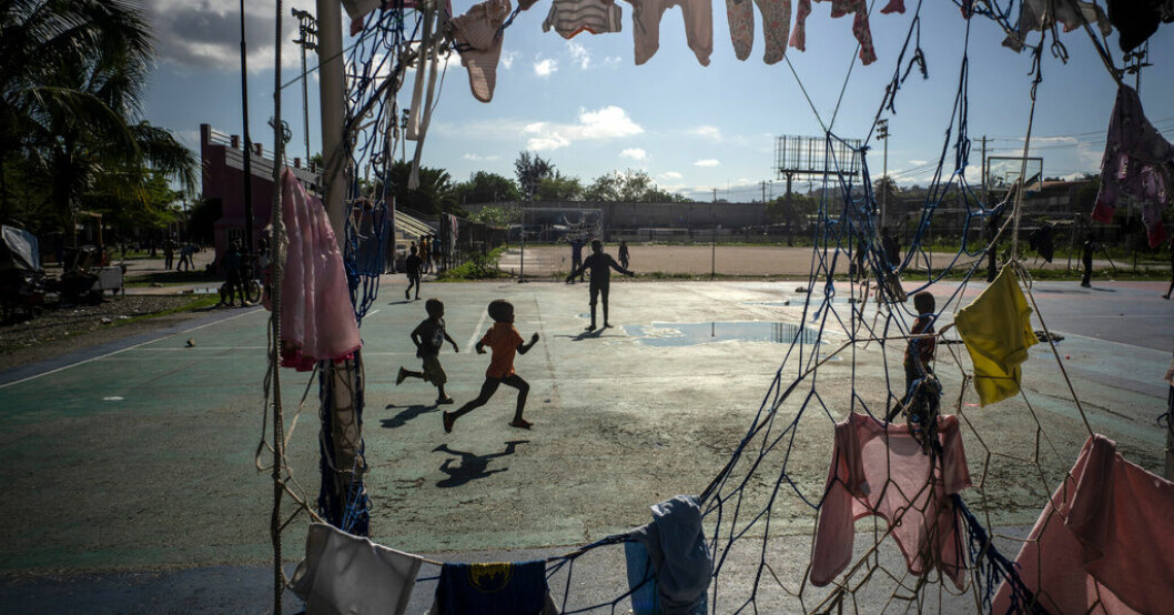 Barn springer på en fotbollsplan i Port-au-Prince där målet används som tvättställning. Bild från oktober 2022. Kidnappningar och plundringar på Haitis skolor