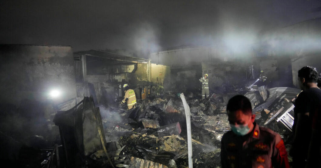 Brandmän inspekterar nedbrunna hus i Jakarta under tidig natt till lördag, lokal tid. Flera döda i bränslebrand i Jakarta