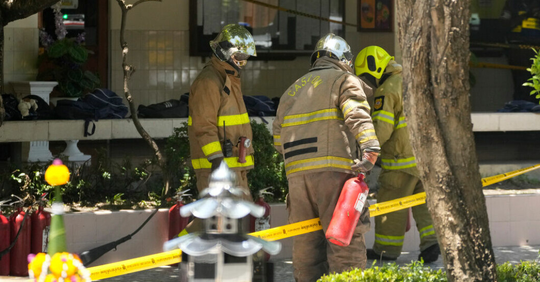 Brandmän undersöker olycksplatsen efter att en brandsläckare exploderat på en skola i Bangkok. Brandsläckare exploderade i Bangkok – elev död