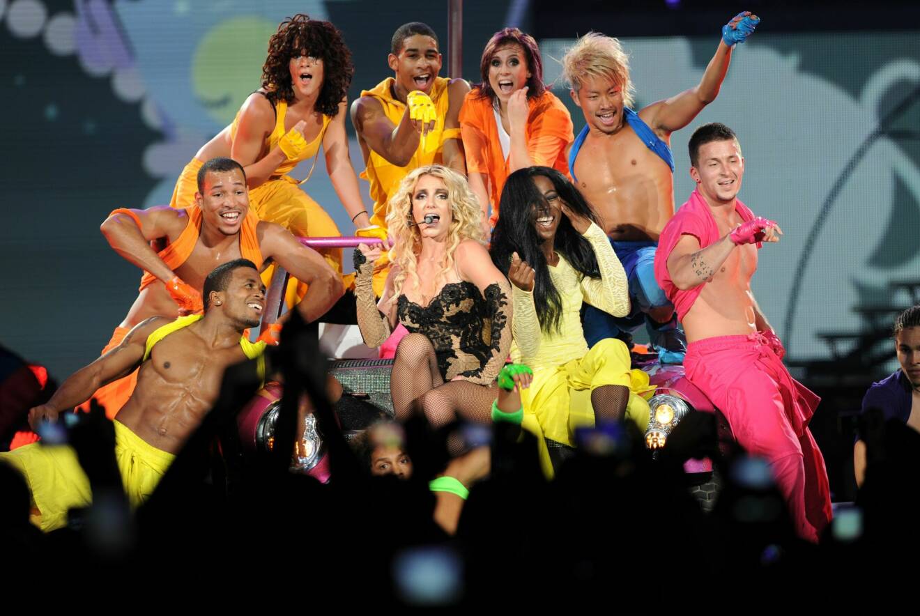 Britney med flera bakgrundsdansare på scenen under Femme Fatale Tour år 2011.