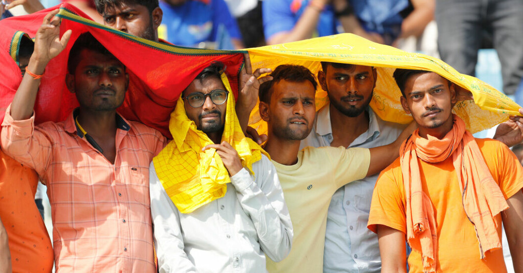 Cricketfans försöker skydda sig från värmen under en match i Lucknow i Indien den 22 april. Klimatförändring bakom extremvärme i Asien