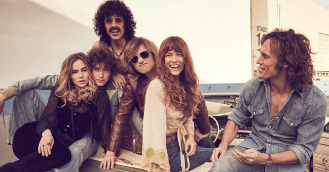 Bandet Daisy Jones & the Six. Sex skrattandes personer sittandes på en bil.