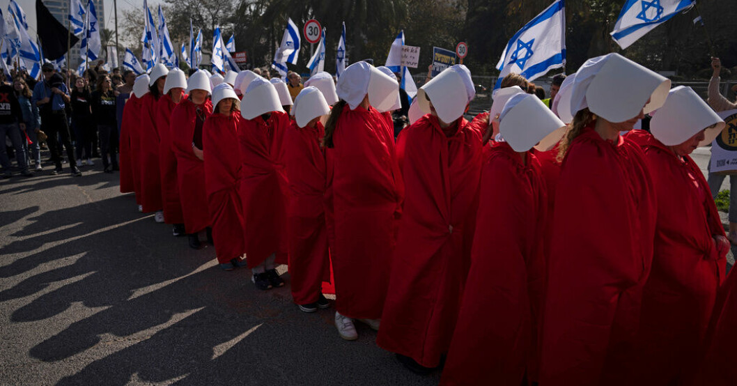 Demonstranter för kvinnors rättigheter klädda i rött och med vita hättor som en referens till tv-serien "The handmaid's tale". De protesterar under måndagen i Tel Aviv mot regeringens planer på att ändra rättsväsendet. Netanyahu pressar på om kritiserat lagförslag