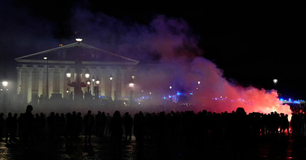 Demonstranter som under fredagskvällen samlats framför parlamentsbyggnaden i Paris. Fransk polis förbjuder protester vid parlamentet