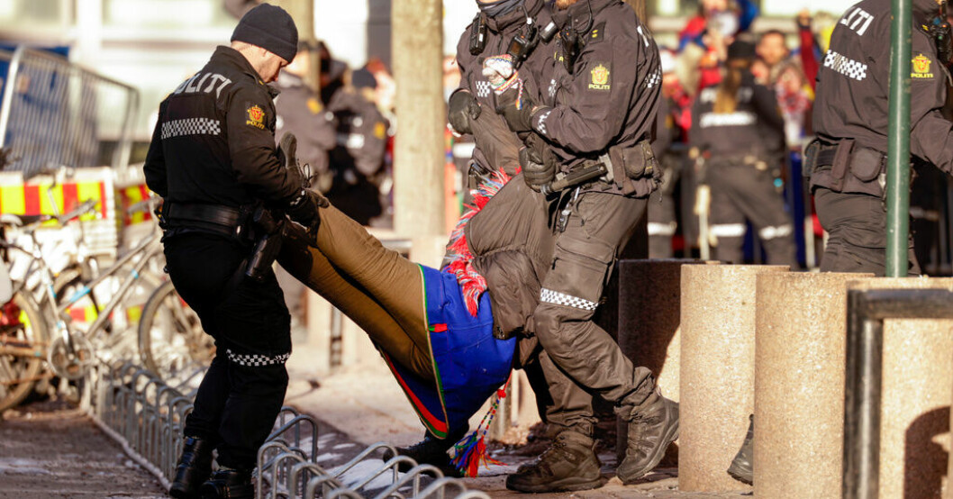 En av demonstranterna bärs i väg av polis i de norska regeringskvarteren. Nya protester i Oslo – samlar 750 000 till böter