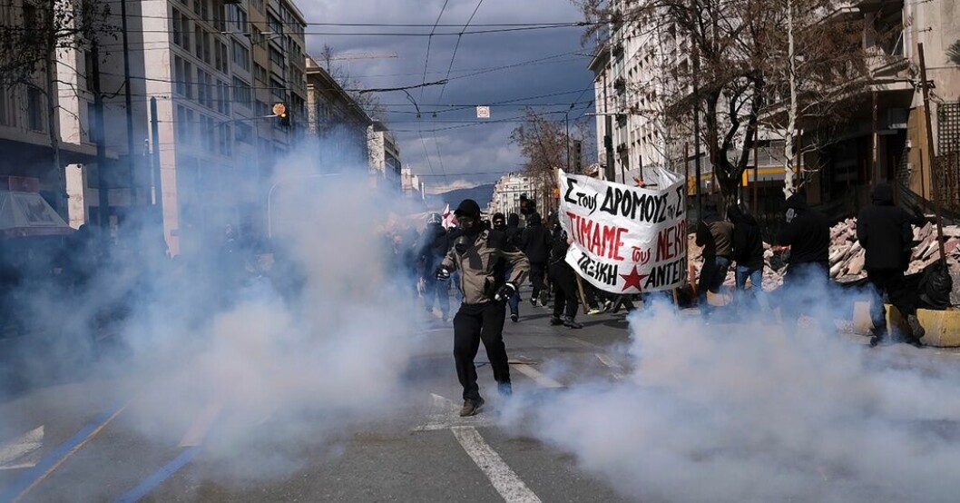 En demonstrant sparkar tillbaka en behållare med tårgas mot kravallpolisen under protesterna i Aten. Tårar och protester efter tågtragedin