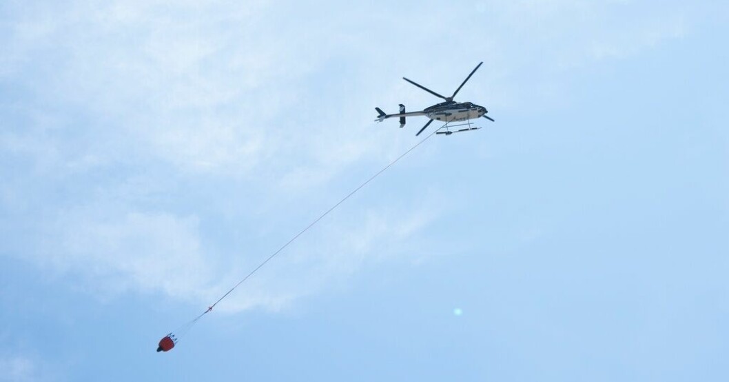 En helikopter med vattenbomber flyger över en skogsbrand i Tantallon i provinsen Nova Scotia i onsdags. Arkivbild. USA och Sydafrika skickar brandmän till Kanada