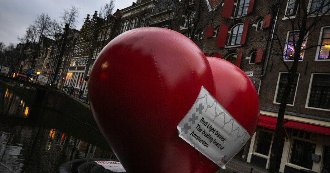 En hjärtformad ballong flyter i en kanal i Amsterdams red light district 2020. Slutpuffat i Amsterdams prostitutionskvarter