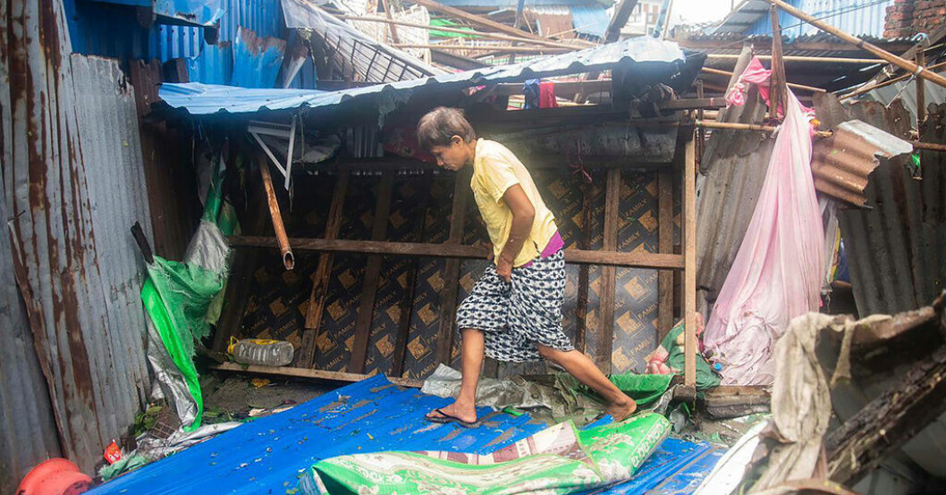 En kvinna går förbi skadade byggnader i delstataten Rakhines huvudstad Sittwe. Flera döda i cyklon i Bangladesh och Myanmar