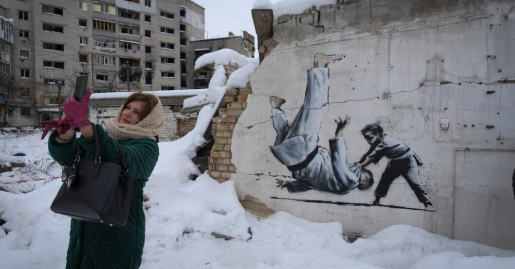 En kvinna tar en selfie vid ett konstverk skapat av brittiska Banksy i Kievregionen i december 2022. Ukrainska influerare ratar ryska – tappar följare