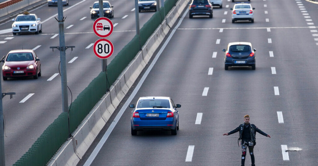 En man försöker blockera en motorväg under fredagens protester i Serbiens huvudstad Belgrad. Serbiska demonstranter kräver slut på tv-våld