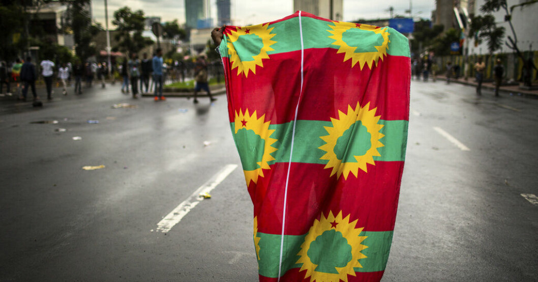 En man iklär sig en av oromoernas rebellgruppers flaggor på en gata i Addis Abeba i september 2018, då gruppens ledare under en period välkomnades tillbaka i huvudstaden. Arkivbild. Larm om ny storoffensiv i Etiopien