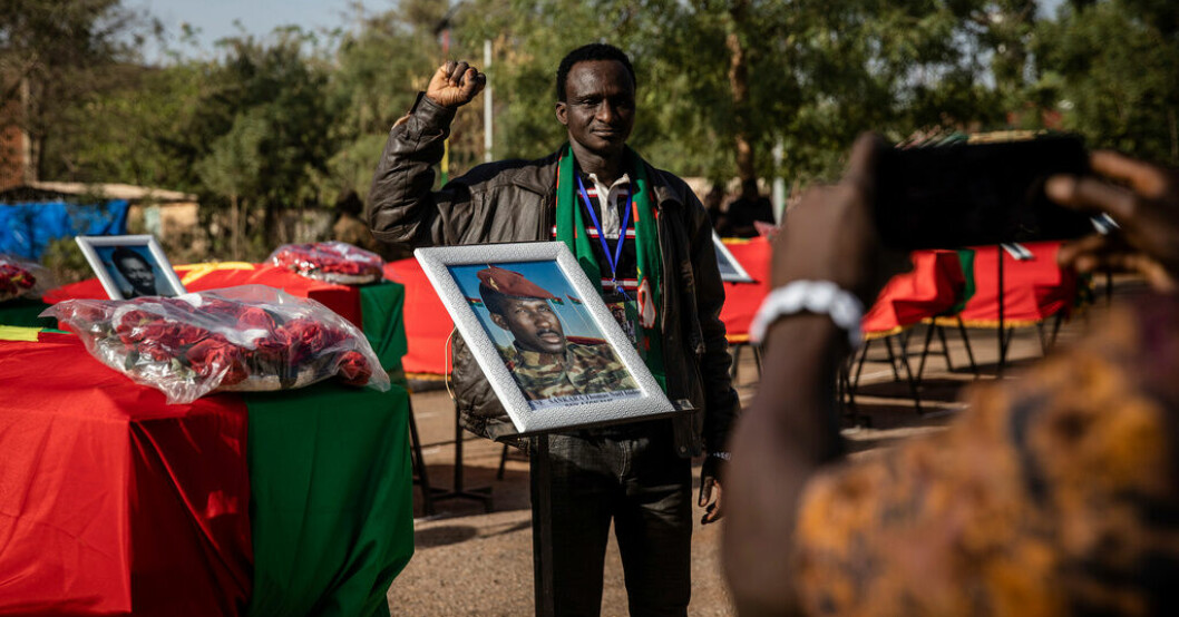 En man poserar bredvid kistan innehållandes Thomas Sankaras kvarlevor i Burkina Fasos huvudstad Ouagadougou. "Afrikas Che Guevara" begravd – för andra gången