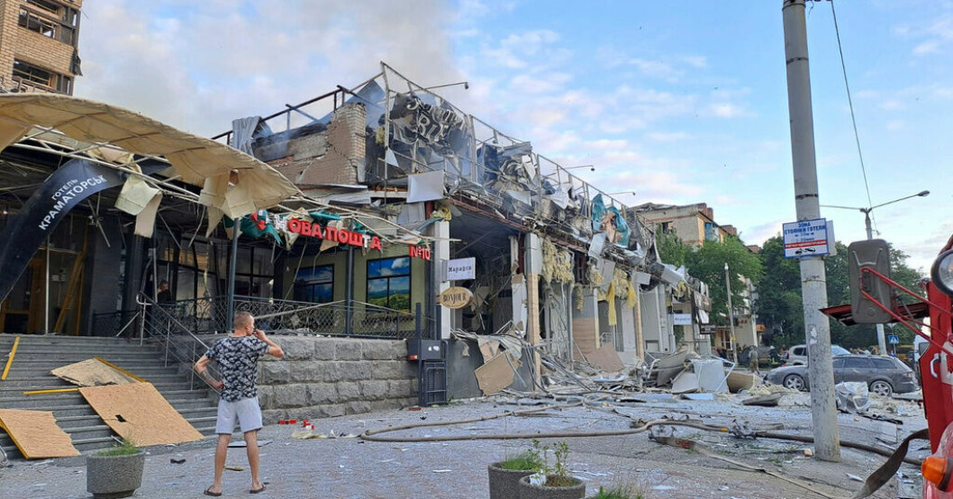 En man står på gatan framför restaurangen i Kramatorsk som träffades i en rysk robotattack. Elva döda efter anfall mot pizzeria i Ukraina