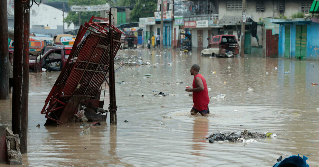 En man vadar genom vattenmassorna på de översvämmade gatorna i Port-au-Prince, Haiti. Minst 15 döda i haitiskt oväder