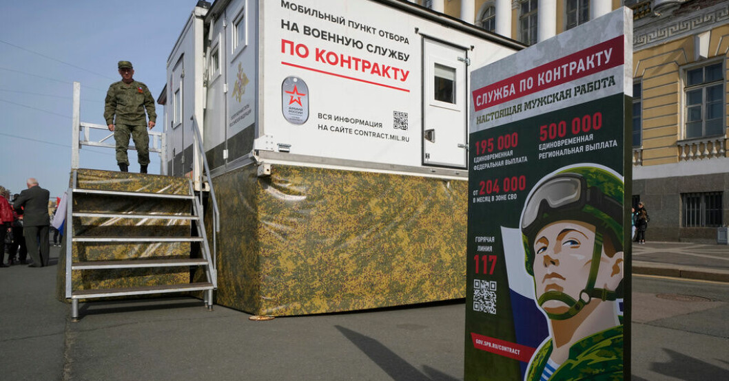 En rysk officer vid ett rekryteringscenter i S:t Petersburg under segerdagen den 9 maj, då Ryssland högtidlighåller Nazitysklands kapitulering i andra världskriget. Migranter mutas med ryska pass för att kriga