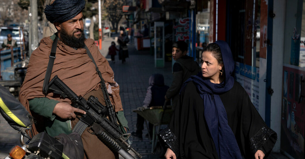 En väpnad taliban patrullerar i Kabul när en kvinna promenerar förbi. Bilden togs den 26 december förra året. "Världen behöver arbeta med talibanerna"