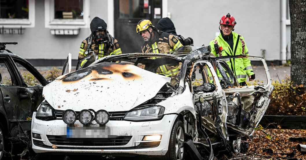 Tre personer från räddningstjänsten står runt bilen som misstänks ha exploderat i Enköping.
