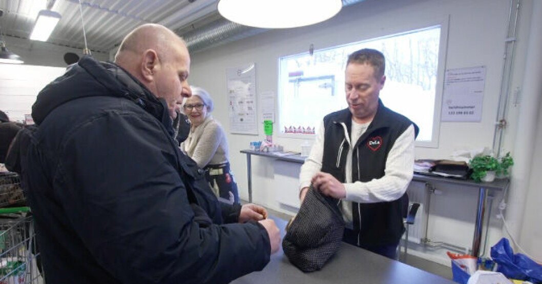 För Ayad är de billigare matvarorna nödvändiga för att han ska ha råd att leva. Ayad betalar för sina varor i kassan.
