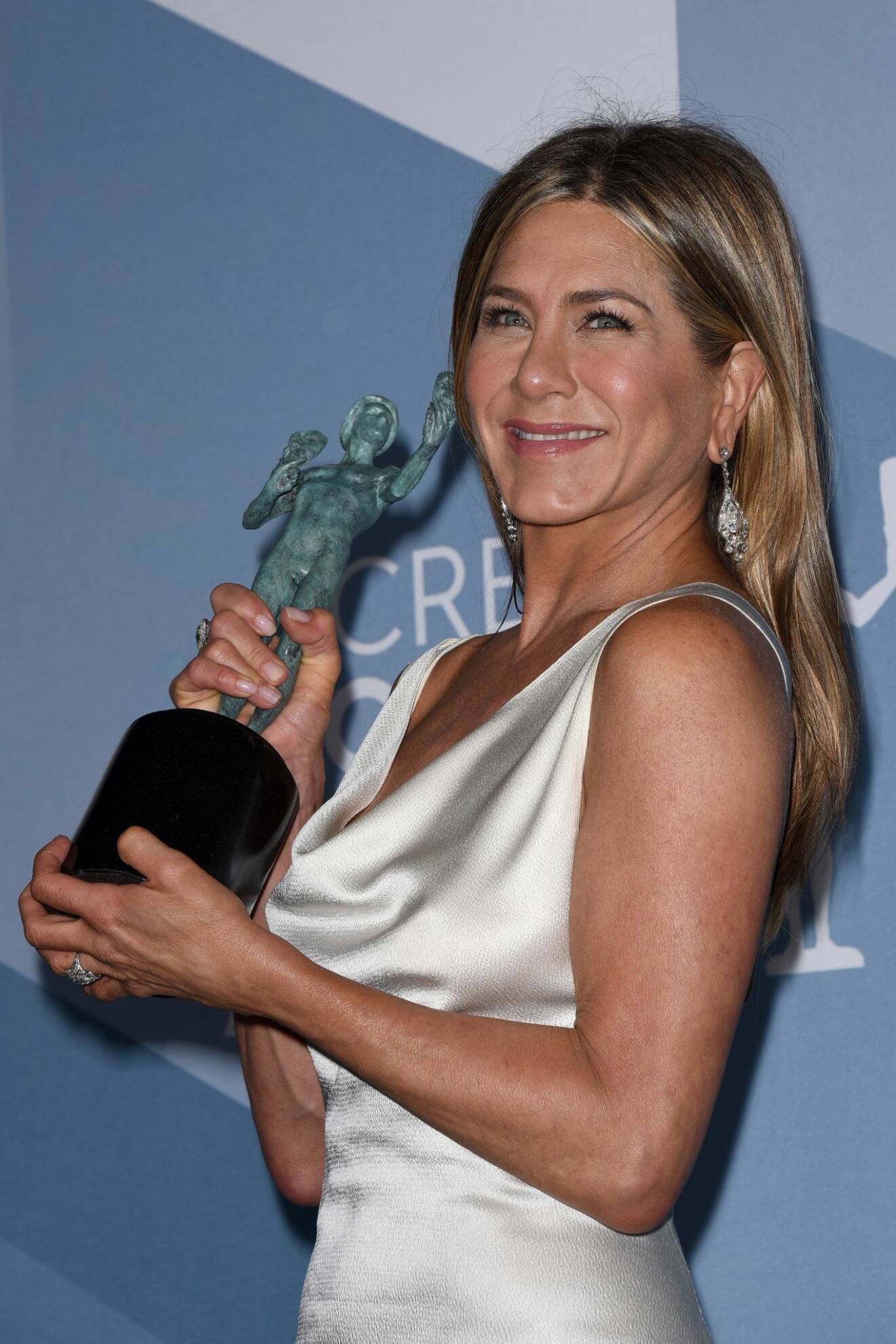 En överlycklig Jennifer Aniston poserar med statyetten under creen Actors Guild Awards. 
