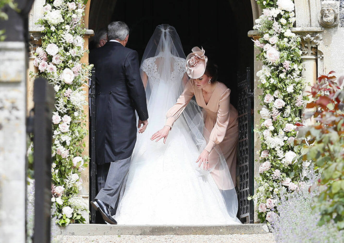 Kate Middleton rättar till sin lillasysters släp innan hon träder fram till altaret. Snart är hon fru. 