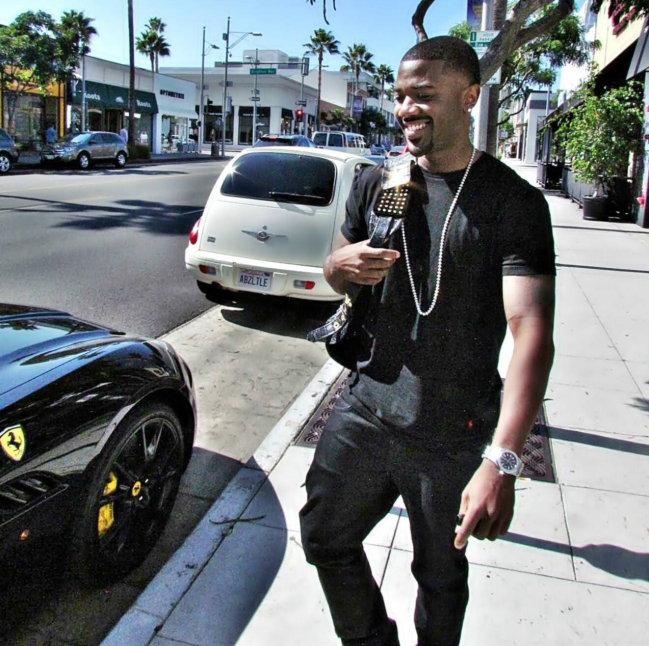Ray J seen wearing a bedazzled backpack as he gets a ride with his manager