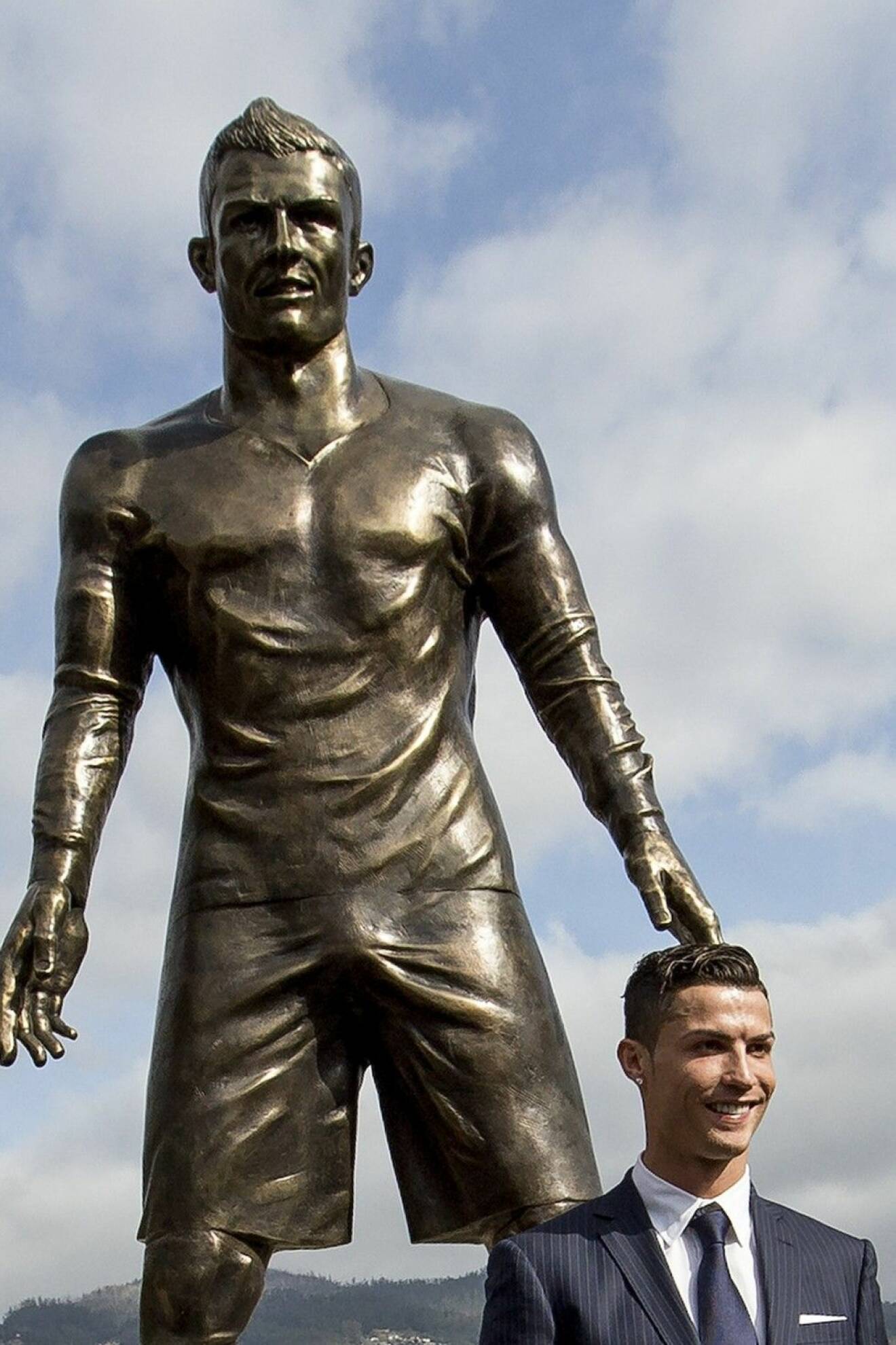 Fotbollsstjärnan med sin omtalade staty. Foto: TT