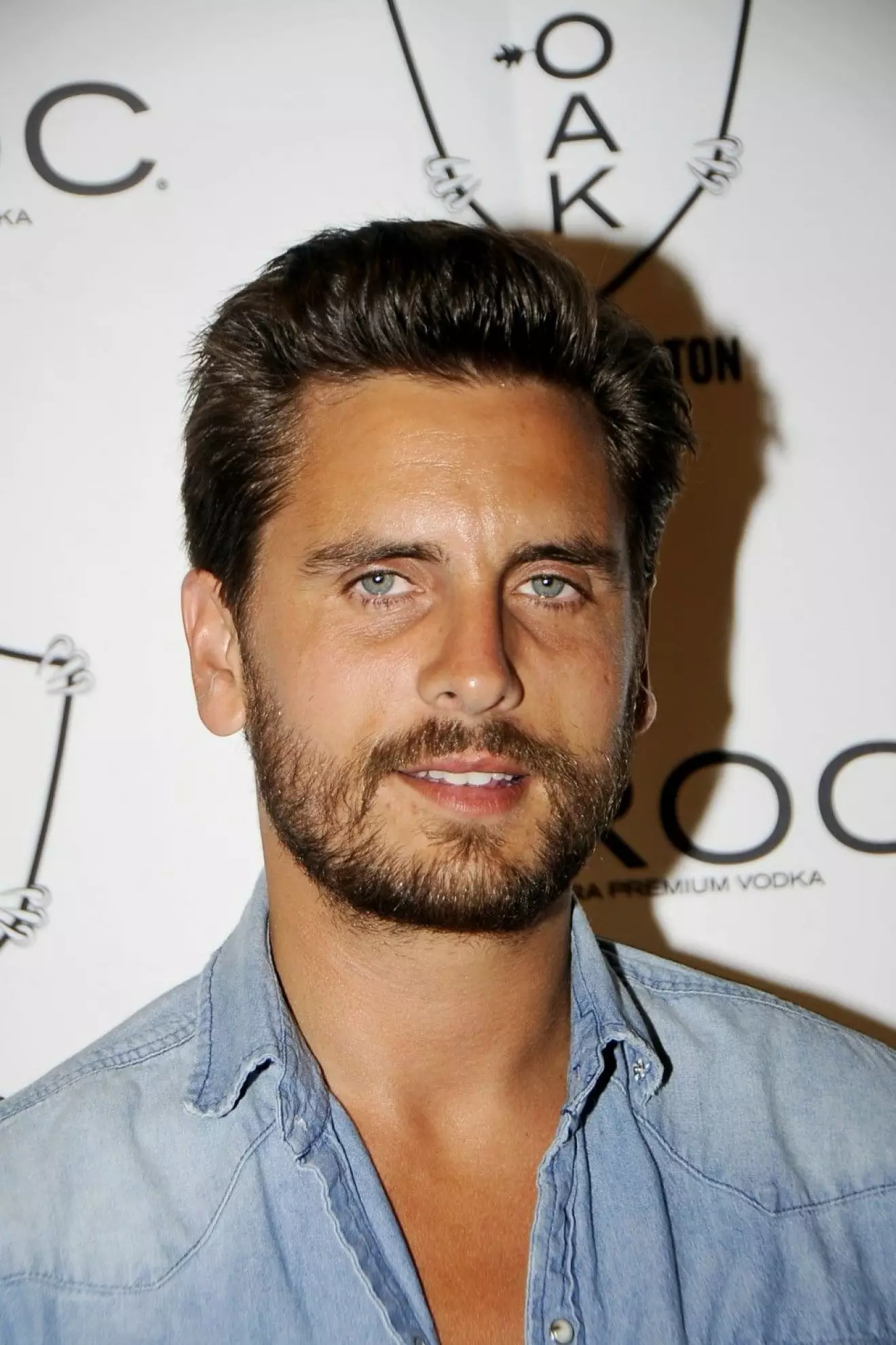 Scott Disick is seen spraying a champagne bottle as he parties at a nightclub in The Hamptons on the night he reportedly ended up in the hospital for Alcohol Poisoning