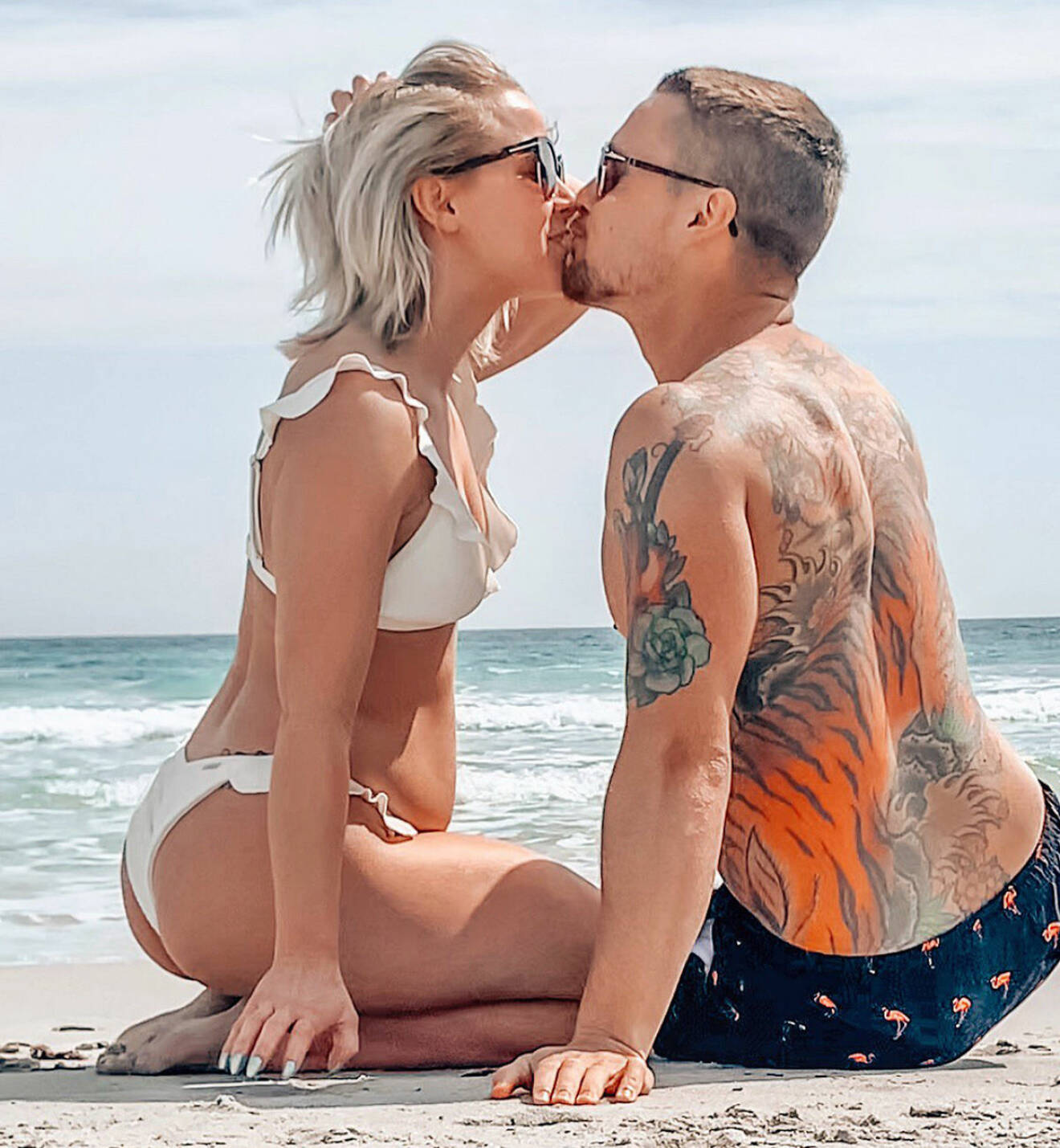  Theodora Larsson och Anton Uddfalk kysser varandra på en strand