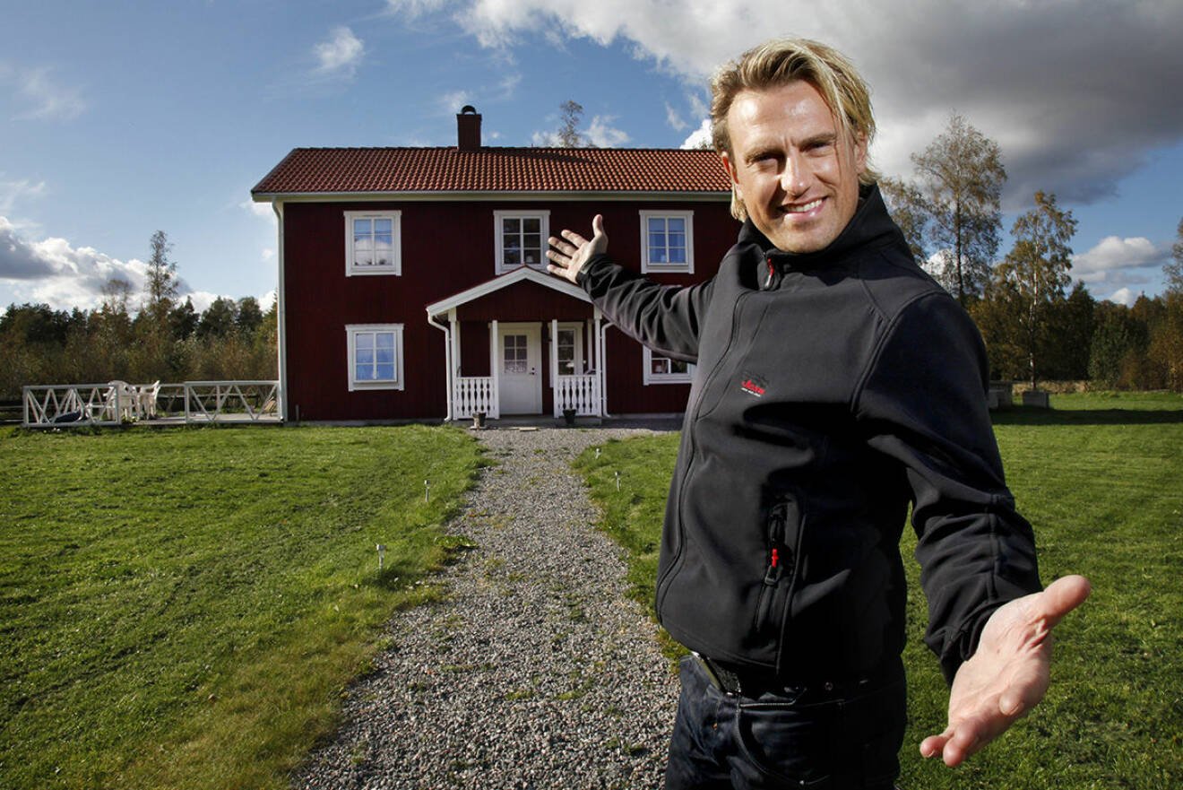 Pär-Ola Nyström i Fjugesta 2011 med sitt då röda hus i bakgrunden
