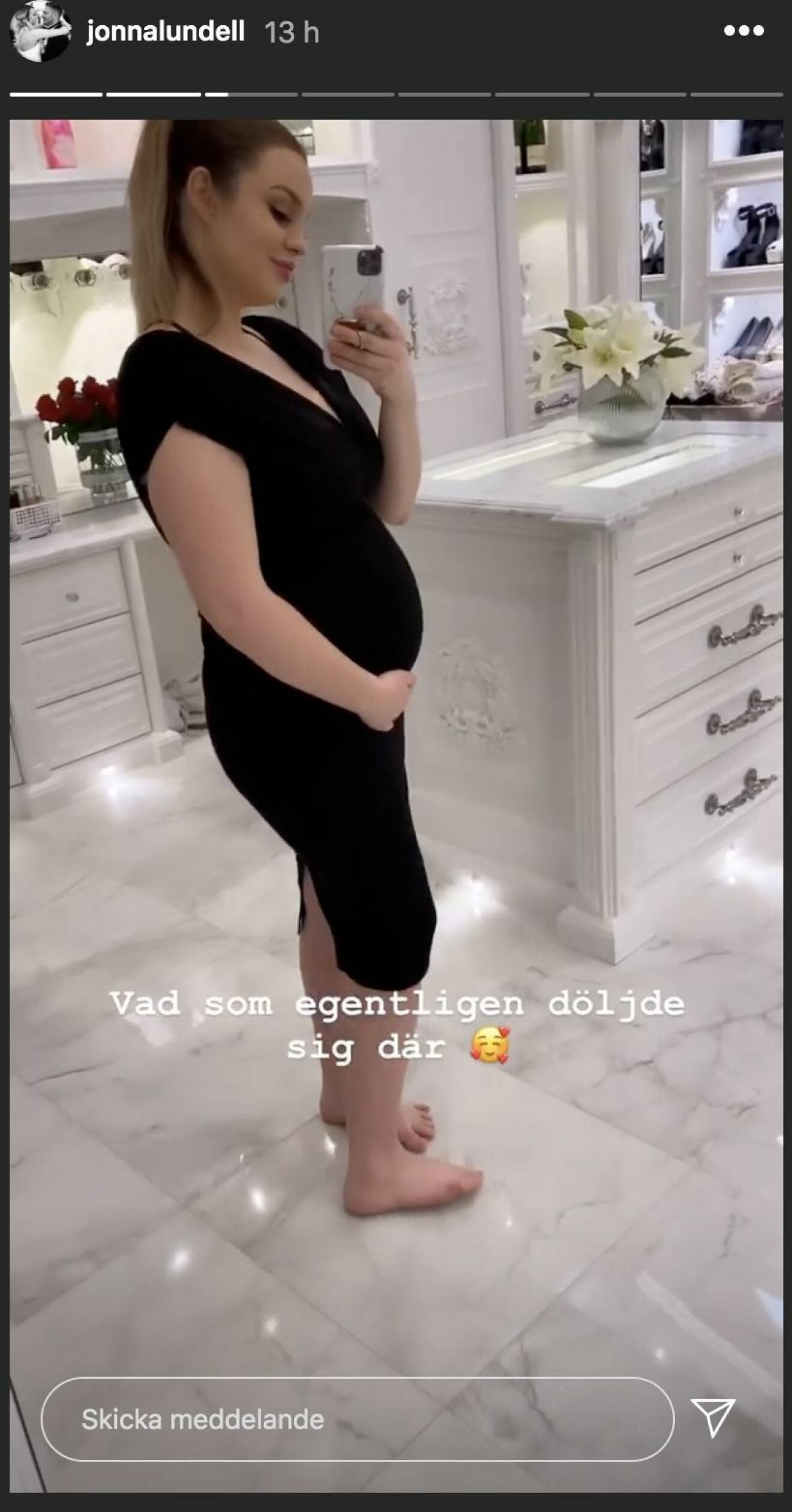 Jonna Lundell i svart klänning visar upp bebismage