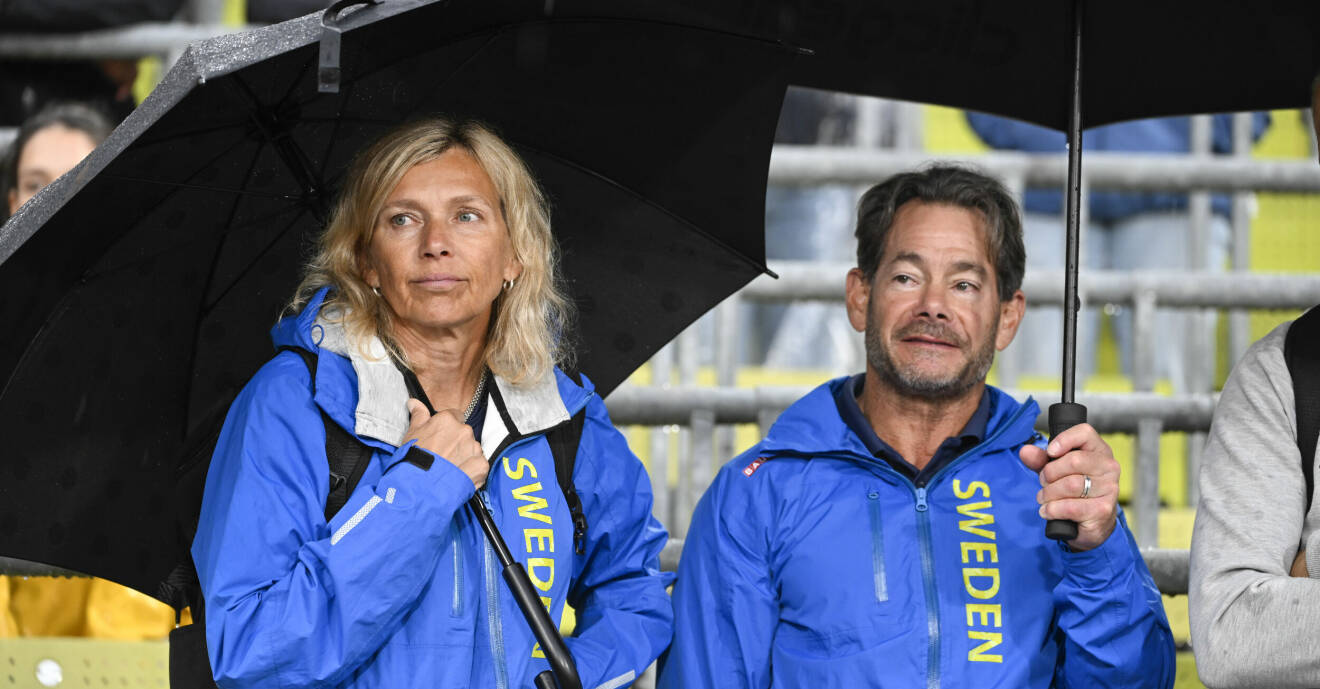 Helena och Greg Duplantis håller i varsitt paraply i blå Sweden-jackor.