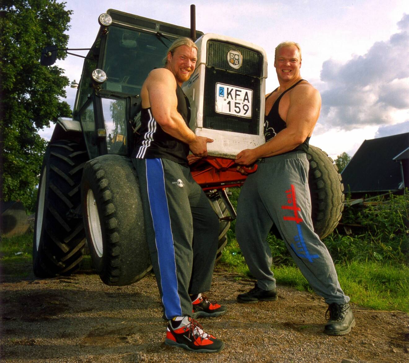 Magnus och hans bror Torbjörn lyfter familjens lilla traktor hemma på gården.