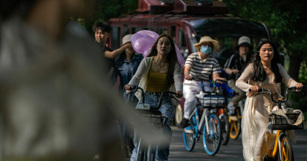 Invånare i Wuhan – staden där coronaviruset först upptäcktes – cyklar i en park den 8 maj. Kina: 65 miljoner covidfall i juni – i veckan