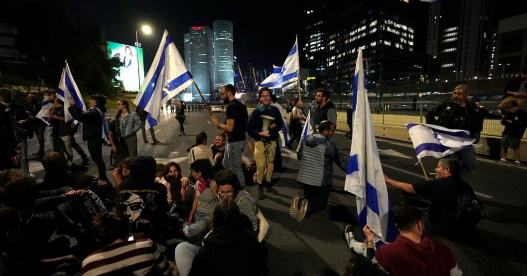 Israeler blockerar en motorväg utanför Tel Aviv i protest mot regeringens förslag att ändra rättsväsendet. Rekordprotester mot rättsligt förslag i Israel