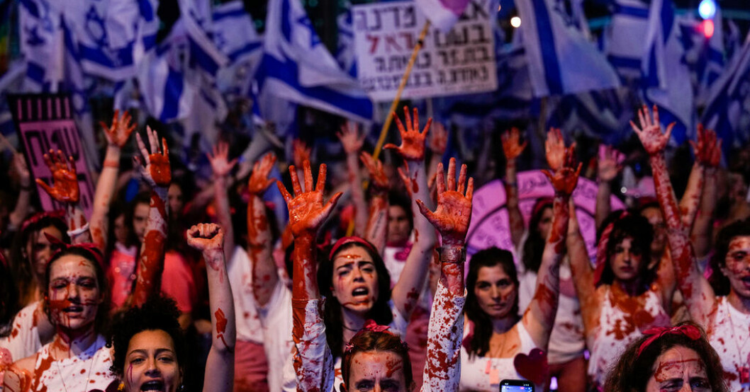 Israeliska aktivister i Tel Aviv som stänkt sig själv i röd färg för att öka kännedomen kring våld mot kvinnor under protesterna mot Netanyahus planerade lagändringar. Tusentals demonstrerar åter mot Netanyahu