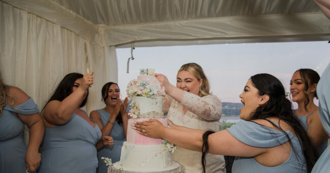 Bruden och brudtärnorna vid bröllopstårtan.