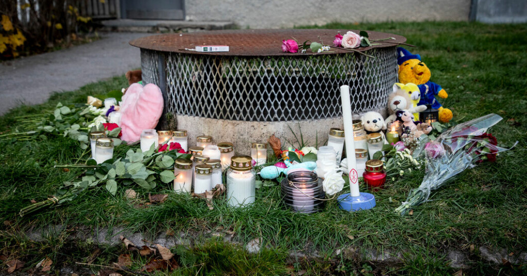 Ljus och blommor på den plats där två barn hittades sedan de kastats ut från en balkong av sin pappa. Arkivbild. Pappa mördade barn – socialtjänsten kritiseras