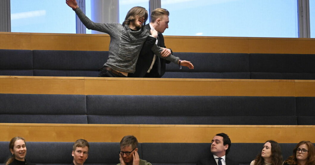 Mannen som protesterade fördes bort av vakter. Protest i riksdagen – man fördes bort av vakter