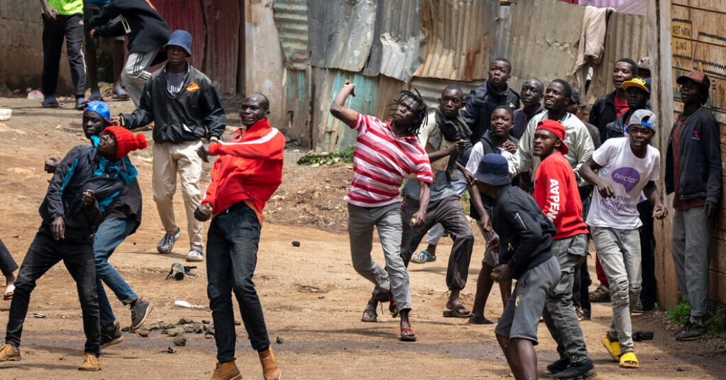 Människor kastar sten mot kravallpolis i slumområdet Kibera i Kenyas huvudstad Nairobi på tisdagen. Våldsamma sammandrabbningar i Kenya