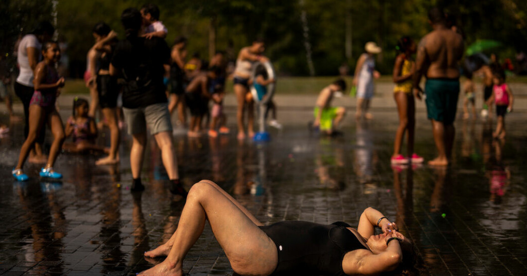 Människor svalkar sig i en park i Madrid under en värmevåg i juli förra året. Arkivbild. EU:s miljöbyrå varnar för extremväder
