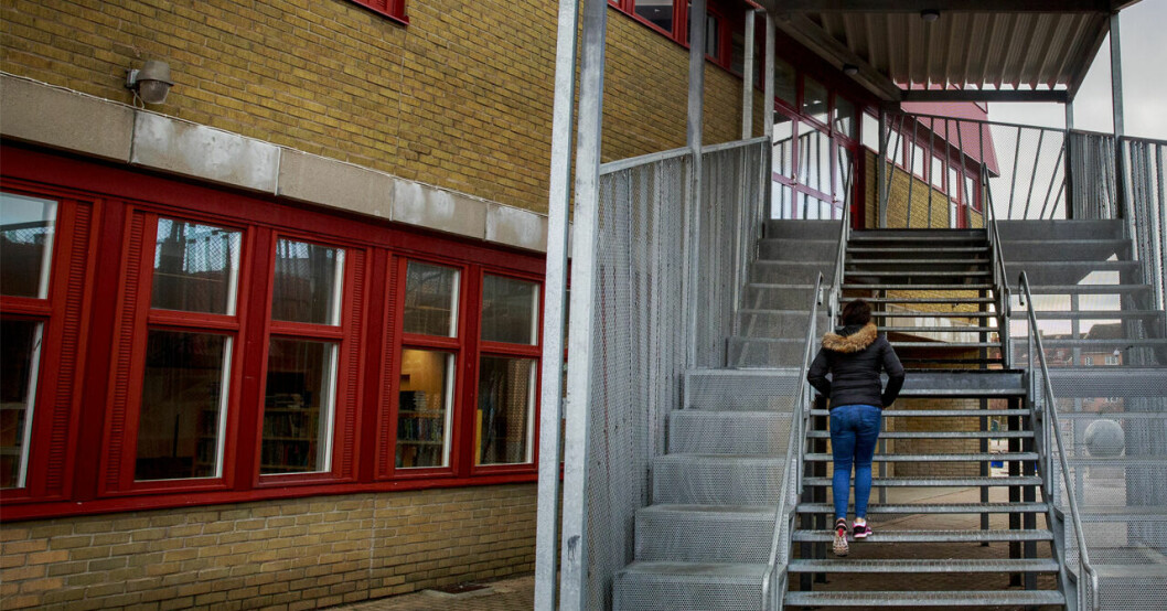 En flicka går uppför en trappa på en skola.