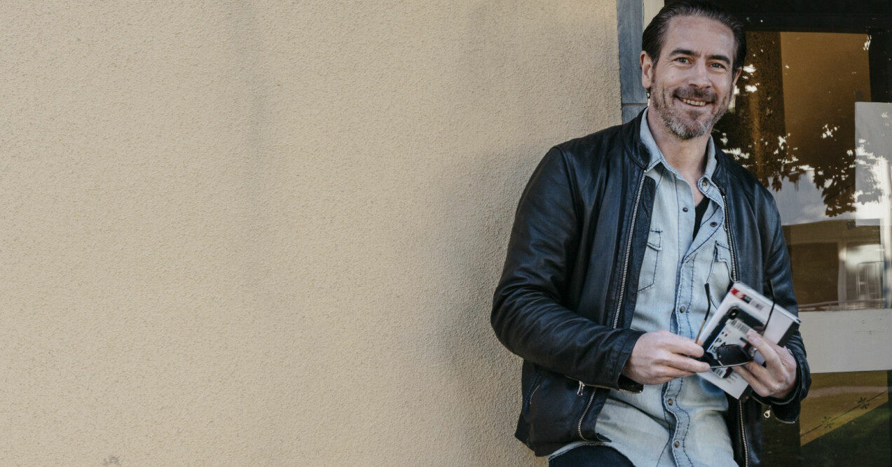 Ola Rapace utanför barndomshemmet med den nya självbiografin. Ola Rapace