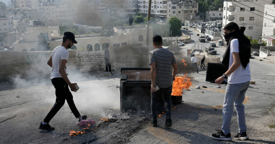 Palestinska ungdomar blockerar en väg under sammandrabbningar med israeliska styrkor i Nablus, som sker efter morgonens israeliska luftangrepp. Kvinnor och barn dödade i israeliskt flyganfall