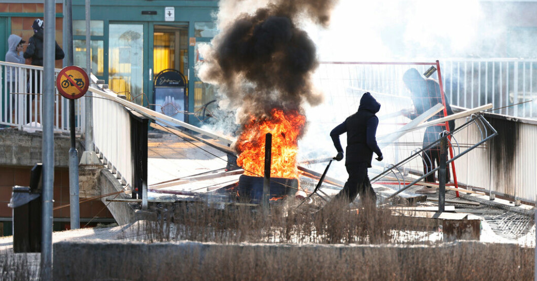 Personer gör en barrikad med brinnade bildäck och andra föremål vid Ringdansen centrum, i samband med upploppet i Navestad i Norrköping under påskdagen 2022. Arkivbild. Fel av polisen att ställa in koranbränning